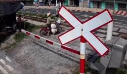 Cố tình băng qua đường ray thì gặp biến, người phụ nữ vội bỏ xe chạy lấy người