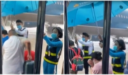 Nhân viên sân bay dầm mưa, đứng cầm ô che cho khách khiến dân mạng thấy rưng rưng