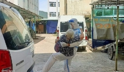 Bức ảnh truyền năng lượng: Chiến sĩ trẻ bế F0 tuổi cao sức yêu từ tầng 4 khu cách ly xuống xe cấp cứu