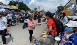 Cô gái trẻ phơi nắng, cầm xấp tiền 500k phát cho dòng người miền Tây hồi hương tránh dịch