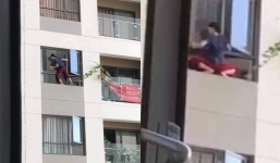 Hốt hoảng người phụ nữ không có đồ bảo hộ, leo ra ban công chung cư lau cửa sổ 