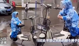 Đợi mẹ giữa trời mưa, cậu bé dùng thân che yên xe để mẹ ngồi không bị ướt