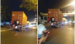 Thót tim nhóm 4 thanh niên đu mình, bám phía sau một xe container đang chạy nhanh