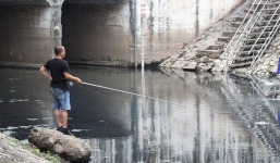 Người đàn ông vác cần ung dung ngồi câu cá trên sông Tô Lịch gây bão MXH