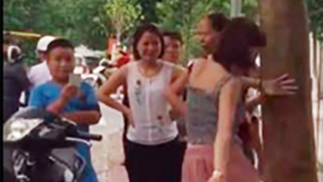 Cô gái thu hút sự hiếu kỳ vì hành động khó hiểu quanh gốc cây