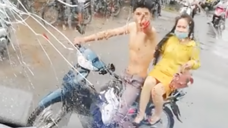 Bị ôtô chạy bắn nước bẩn lên người, nam thanh niên chở bạn gái đuổi theo cầm gạch ném vỡ kính xe