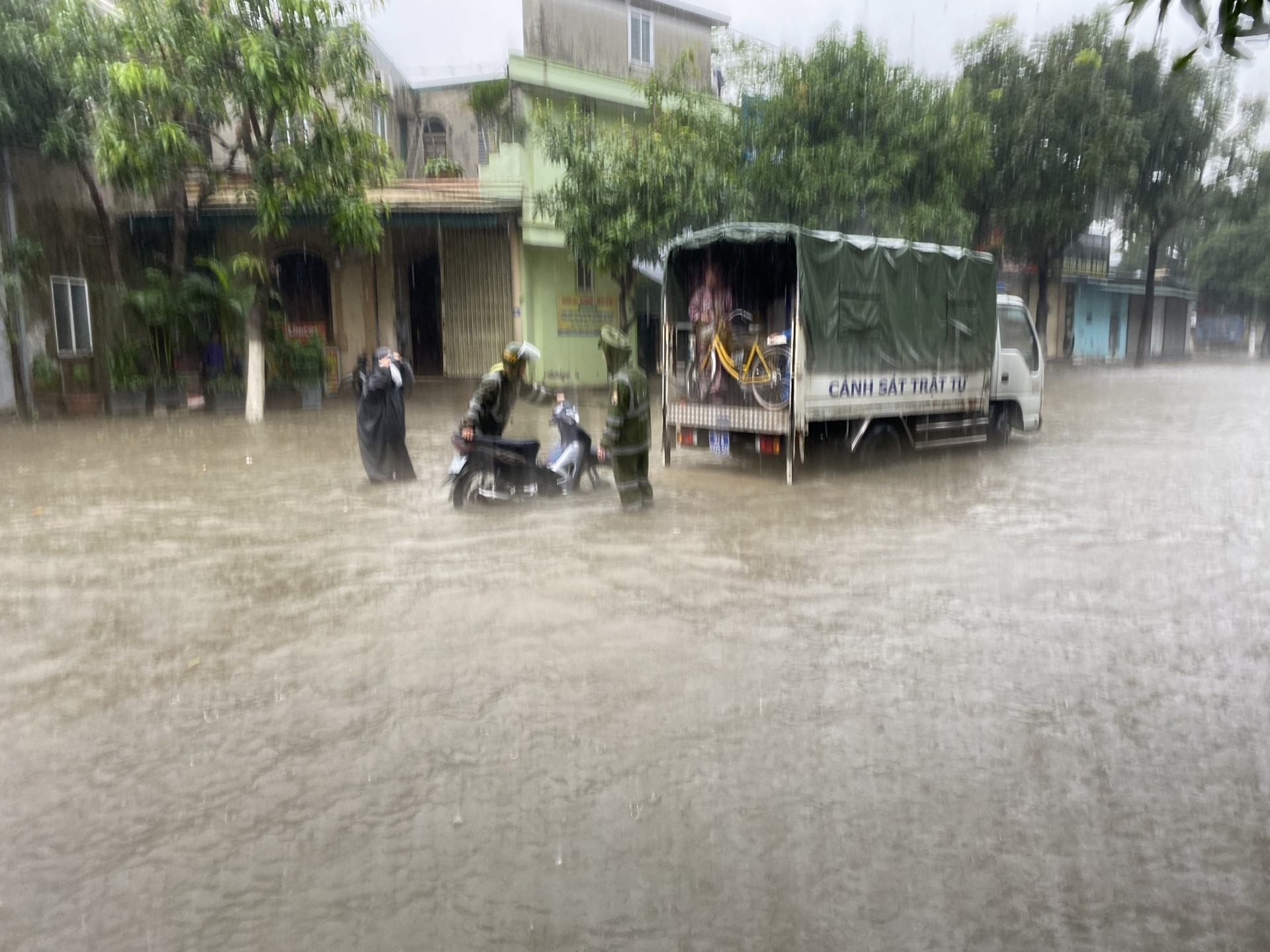 Những cán bộ chiến sỹ CSGT,TT không ngại mưa gió dầm mình trong nước để giúp dân đẩy ô tô, xe máy qua các điểm ngập úng.