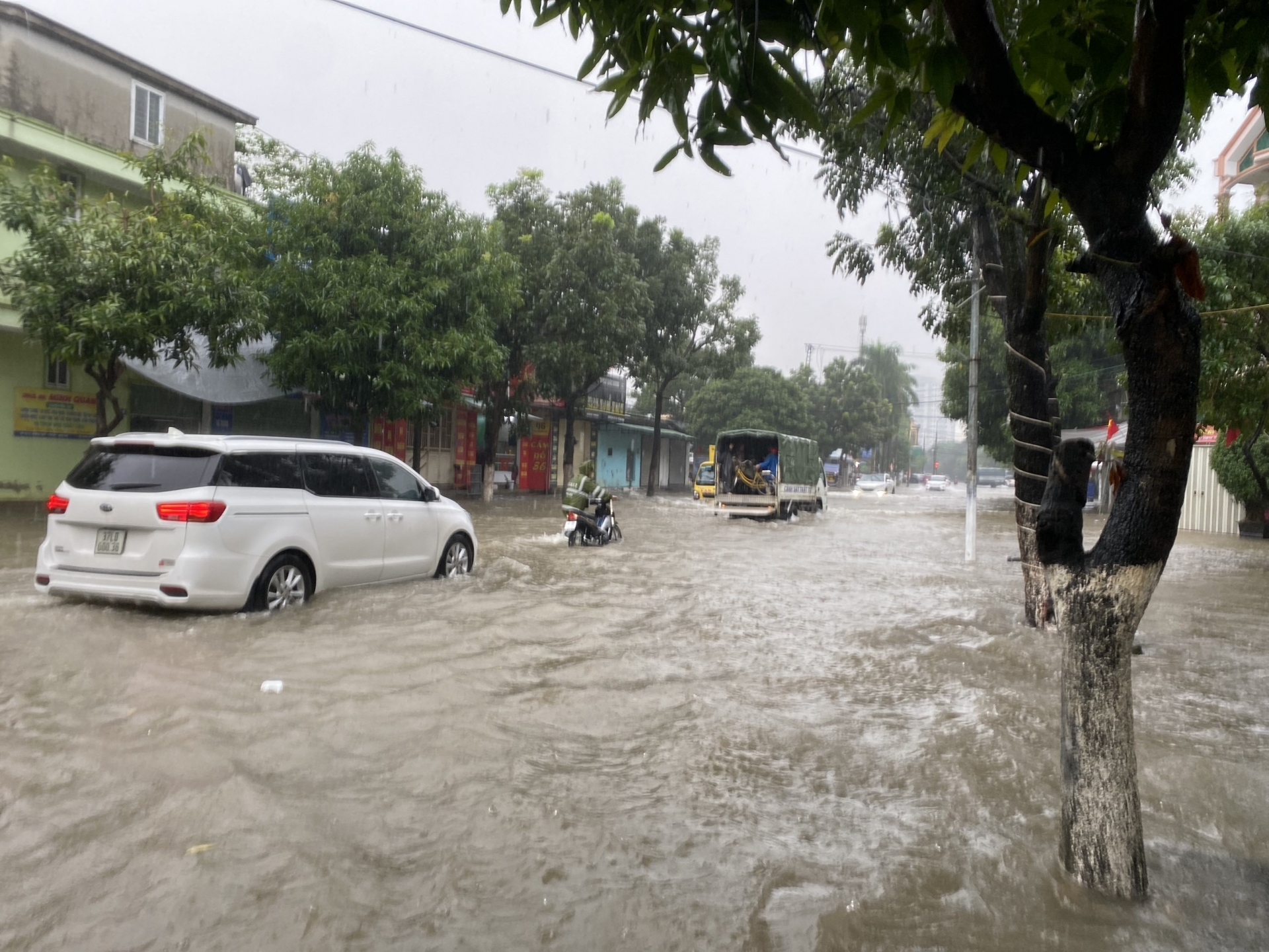 Một chiến sĩ hỗ trợ người dân dắt xe chết máy qua đoạn ngập.