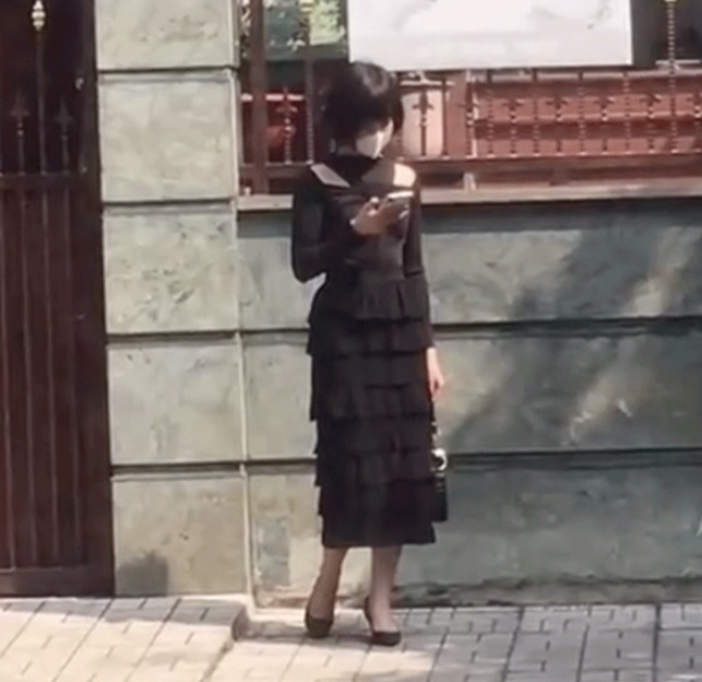 Cô gái được cho là Hải Tú đứng một mình bơ vơ giữa ồn ào. Ảnh internet