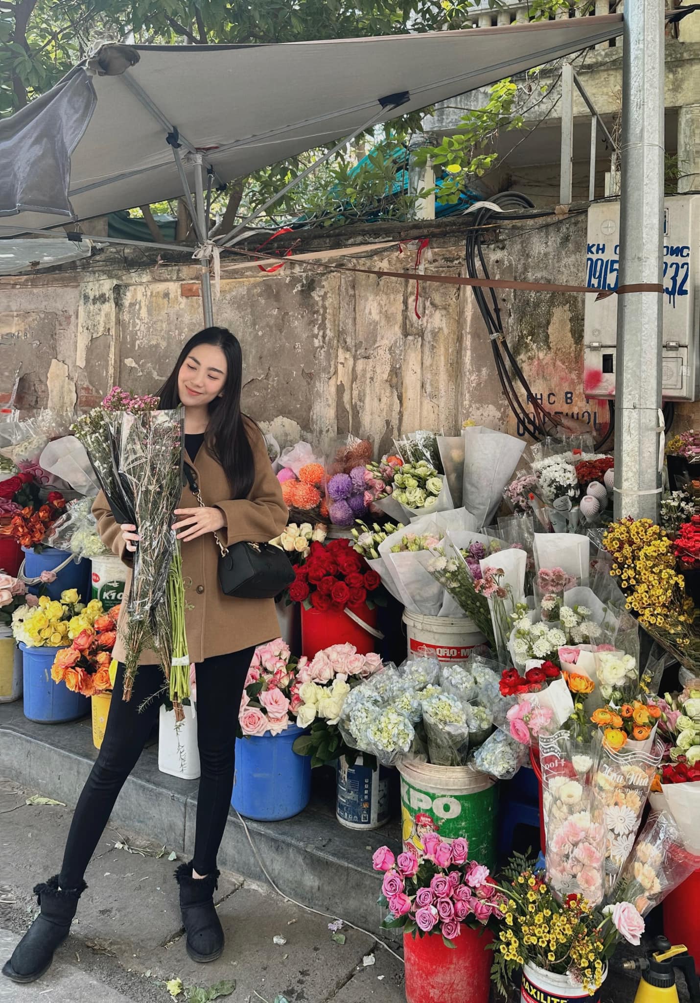 MC Mai Ngọc rạng rỡ đi mua hoa giữa tiết trời lạnh giá. Ảnh internet
