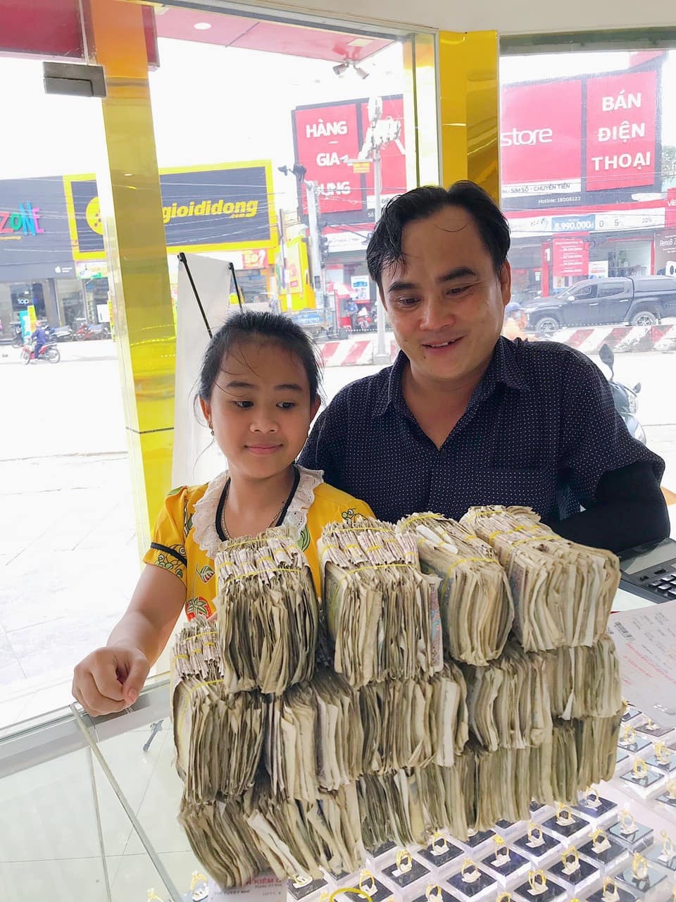 Hình ảnh anh Tấn dẫn con gái đi mua vàng với xấp tiền lẻ được chia sẻ rộng rãi những ngày qua.Ảnh: NVCC/báo Thanh Niên