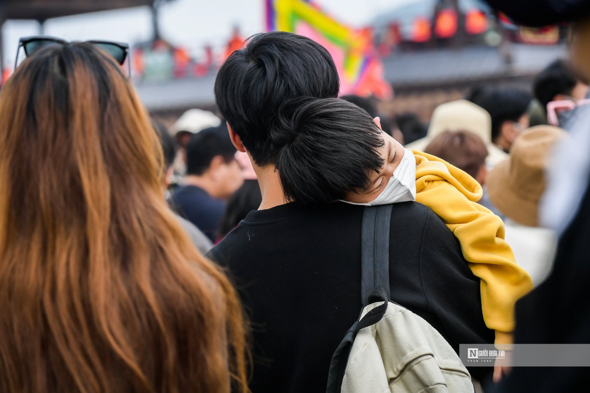 Những em bé được bố mẹ cõng trên vai, ngủ giấc tạm để vượt qua đoạn ùn tắc.