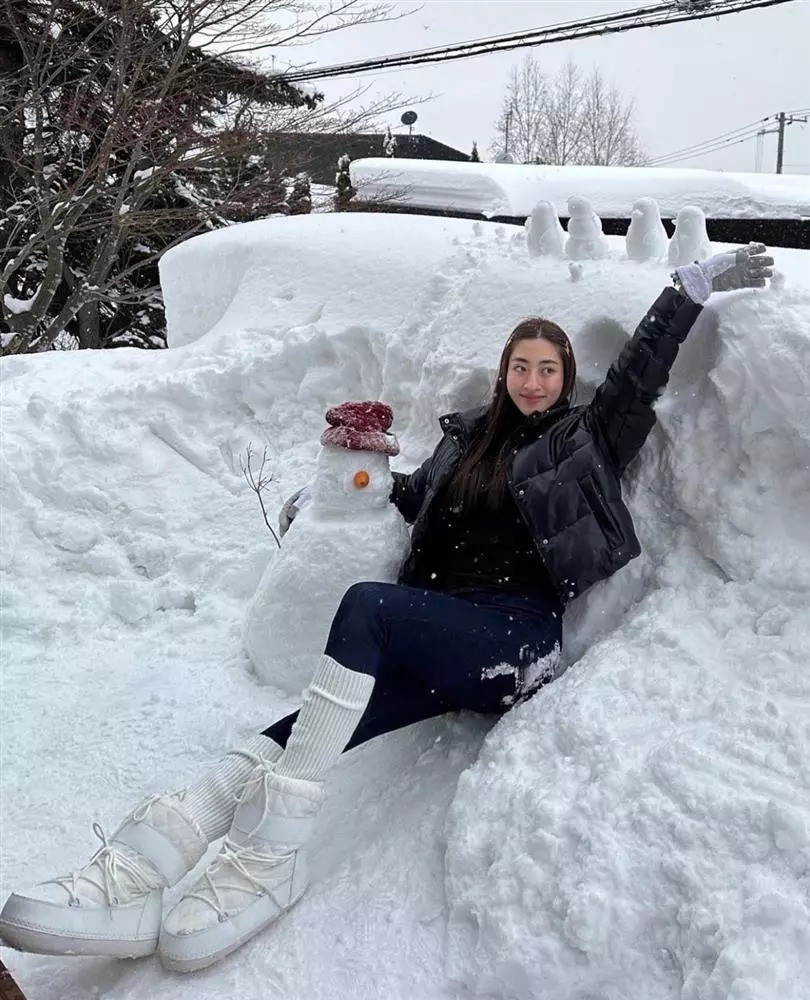 Lương Thuỳ Linh diện trang phục ấm áp gồm áo phao và boots lông, hào hứng tạo dáng bên 'bạn trai' thực chất là một hình nộm người tuyết mà thôi.