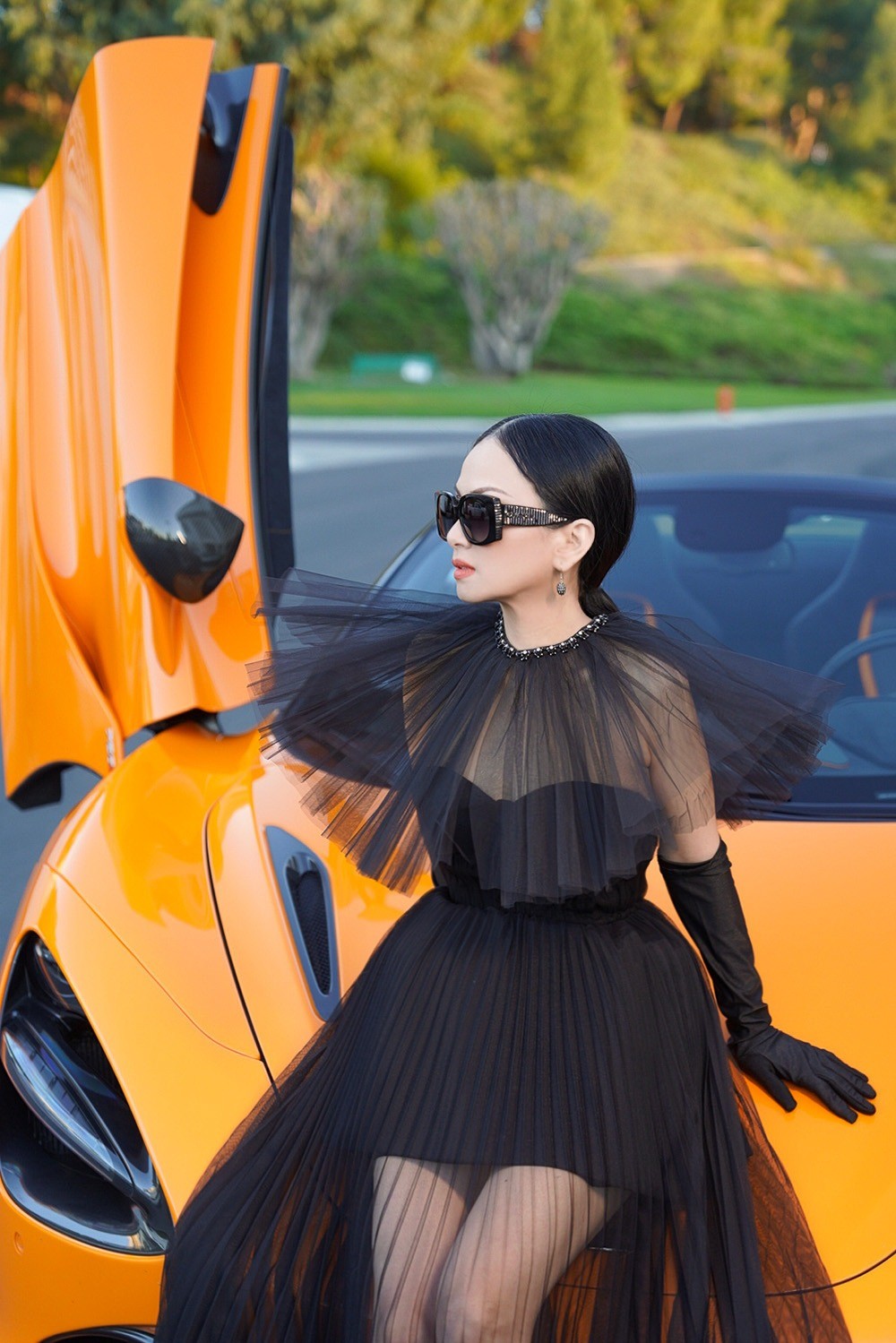 Bộ váy tông đen cúp ngực, chân váy xuyên thấu kết hợp những điểm nhấn độc đáo giúp ca sĩ tỉ phú như trẻ ra cả chục tuổi.