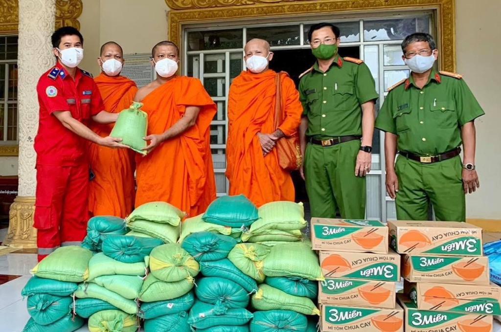 Anh Phong (ngoài cùng bên trái) đại diện Đội thanh niên xung kích tỉnh Trà Vinh kết hội chính quyền địa phương vận động hỗ trợ lương thực thực phẩm và rau củ quả hỗ trợ cho các chùa Phật giáo Nam tông Khmer tại huyện Trà Cú, tỉnh Trà Vinh trong đợt đại dịch Covid-19.