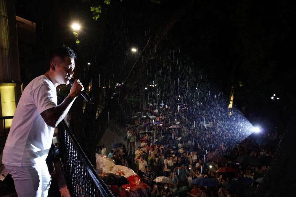 Khoảnh khắc mặc mưa như trút nước, fan vẫn đứng kín cổng nhà Tuấn Hưng nghe hát (Ảnh: FBNV)