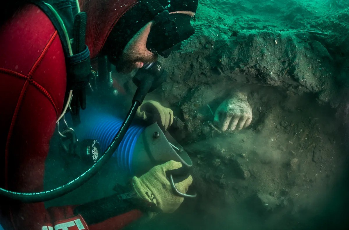 Các nhà khảo cổ phát hiện một bức tượng một bàn tay vàng đang nổi lên từ lớp trầm tích trong một cuộc khai quật khảo cổ ở Thonis-Heracleion. Hình ảnh được cung cấp bởi Christoph Gerigk ©Franck Goddio/Hilti Foundation.