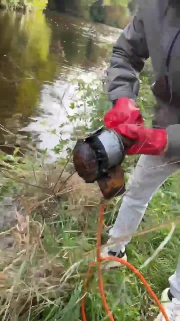 Đoạn video cho thấy một trong những ngư dân đang cầm quả lựu đạn rỉ sét, ngòi nổ chưa được kích hoạt.  Ảnh: New York Post