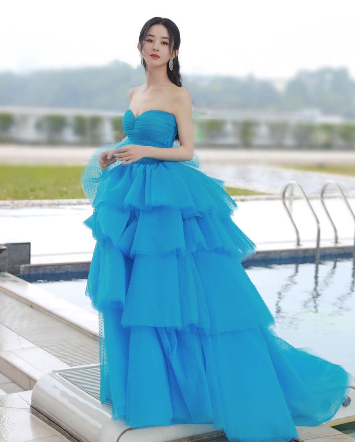 Triệu Lệ Dĩnh cũng lựa chọn chiếc váy xếp tầng màu xanh nước biển cúp ngực của thương hiệu Monique Lhuillier. Bà mẹ một con ngày càng nhận được lời khen về nhan sắc lên hương sau khi sinh.