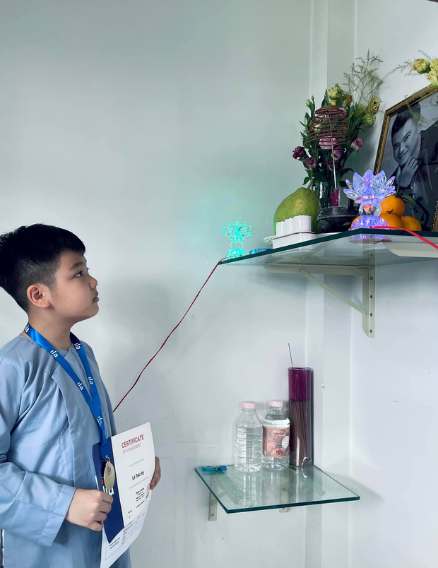 Hình ảnh hai bé con của cố NS Vân Quang Long cầm giấy khen đứng trước di ảnh bố gây xúc động. Ảnh: Facebook Hình ảnh hai bé con của cố NS Vân Quang Long cầm giấy khen đứng trước di ảnh bố gây xúc động. Ảnh: Facebook