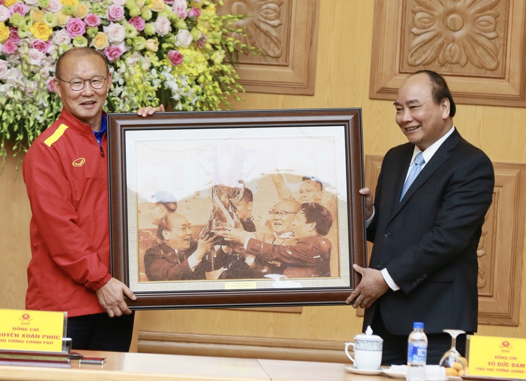 Thủ tướng Nguyễn Xuân Phúc trao tặng món quà lưu niệm cho HLV Park Hang-seo sau khi nhận được quả bóng kỷ niệm từ các thành viên của đội tuyển Việt Nam hồi năm 2018. Ảnh: VGP