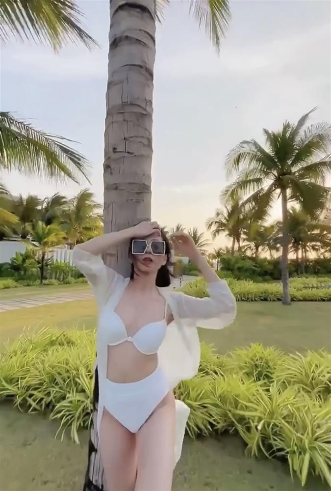 Diện bộ bikini trắng, nữ ca sĩ sinh năm 1981 kết hợp với áo choàng mỏng ton sur ton và đeo kính râm bản to cực sang chảnh.