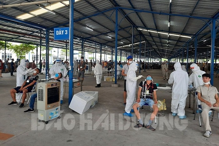 Ngày 20/5, lực lượng chức năng khẩn trương lấy mẫu bệnh phẩm xét nghiệm cho toàn bộ 18.000 công nhân Công ty TNHH May Tinh Lợi (khu công nghiệp Lai Vu, Kim Thành) do liên quan đến 1 nhân viên của công ty mắc COVID-19. Ảnh: Báo HD