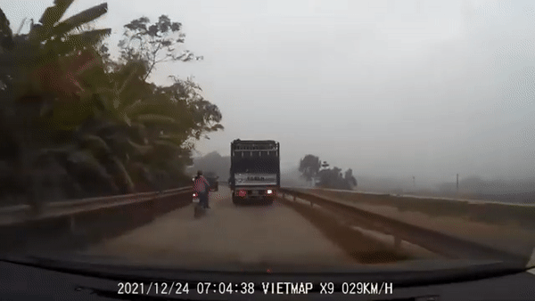 Liều lĩnh lách giữa 2 xe tải để vượt lên trước, người phụ nữ may mắn thoát nạn thần kì 
