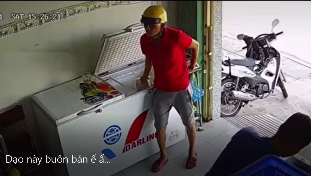 Người đàn ông áo đỏ tiếp cận chiếc tủ và quan sát