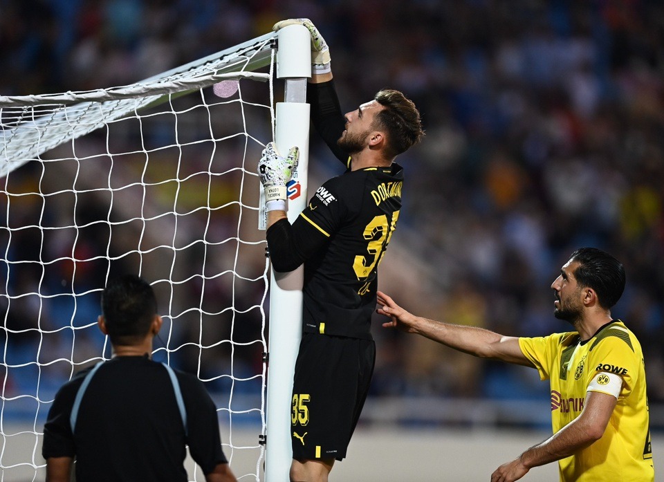 Thủ môn Dortmund cố gắng khắc phục sự cố trên sân Mỹ Đình. Ảnh: Internet