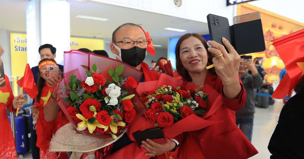 CĐV Việt Nam tại Lào đón đội tại sân bay Wattay và tặng hoa chúc mừng HLV Park Hang-seo. Ảnh: VFF