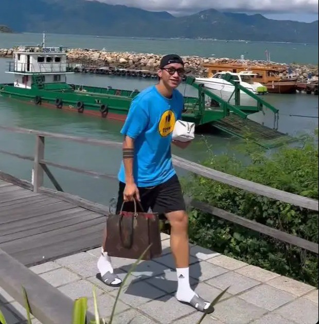 Văn Hậu diện áo phông xanh, quần đùi, đội mũ lưỡi trai ngược và đeo kính râm thời trang Văn Hậu diện áo phông xanh, quần đùi, đội mũ lưỡi trai ngược và đeo kính râm thời trang