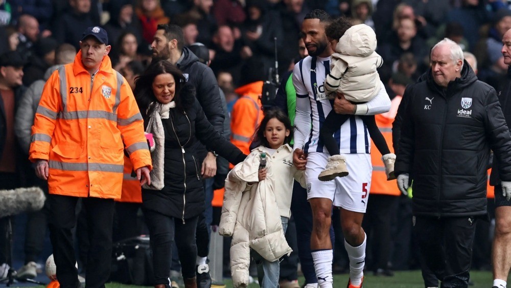 Hậu vệ Kyle Bartley phải ôm con gái rời khán đài. Ảnh: Internet Hậu vệ Kyle Bartley phải ôm con gái rời khán đài. Ảnh: Internet