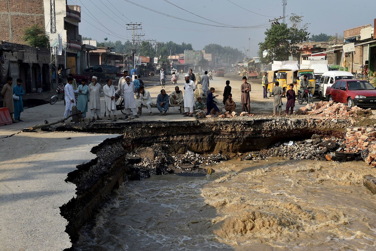 Người dân tập trung bên cạnh một con đường bị hư hại do lũ lụt ở Kyhber Pakhtunkhwa, Pakistan ngày 29/8. Ảnh: Getty