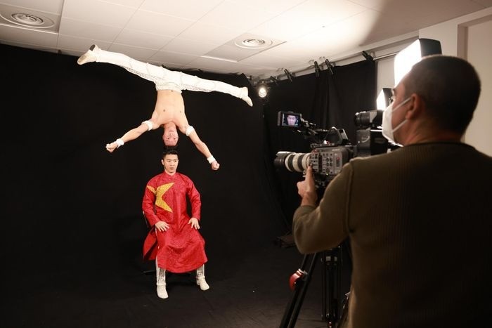 Quốc Cơ, Quốc Nghiệp mặc áo dài đỏ, in sao vàng trả lời phỏng vấn tại Milan. Ảnh: VNN