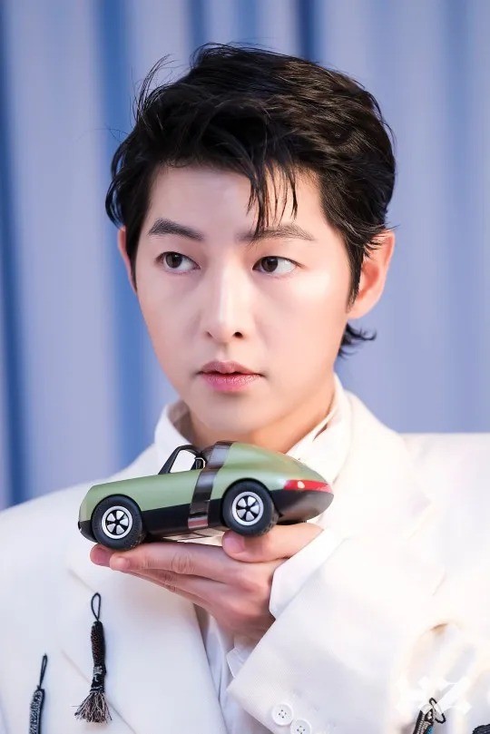 Món đồ chơi càng tăng thêm nét trẻ thơ cho Song Joong Ki.