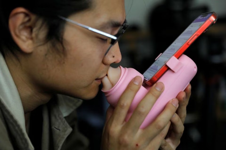 Zhao Jianbo trình diễn nụ hôn với máy MUA. Ảnh: Reuters