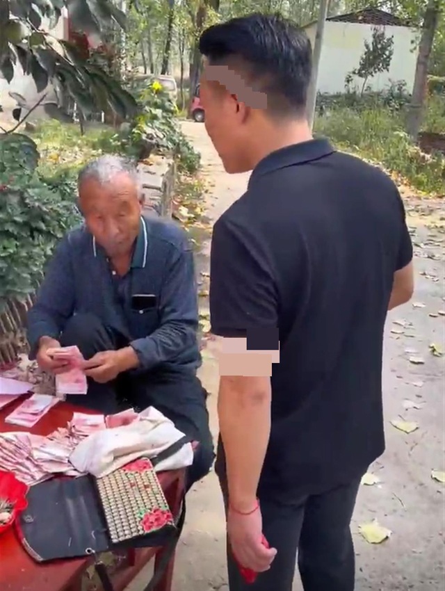 Hình ảnh người đàn ông đến xin lại tiền mừng khiến dân tình chỉ biết cười bò. Ảnh chụp từ clip