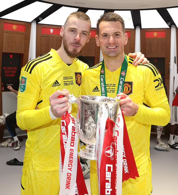 Thủ môn David de Gea cùng Tom Heaton tạo dáng bên chiếc cup vô địch. Thủ môn David de Gea cùng Tom Heaton tạo dáng bên chiếc cup vô địch.