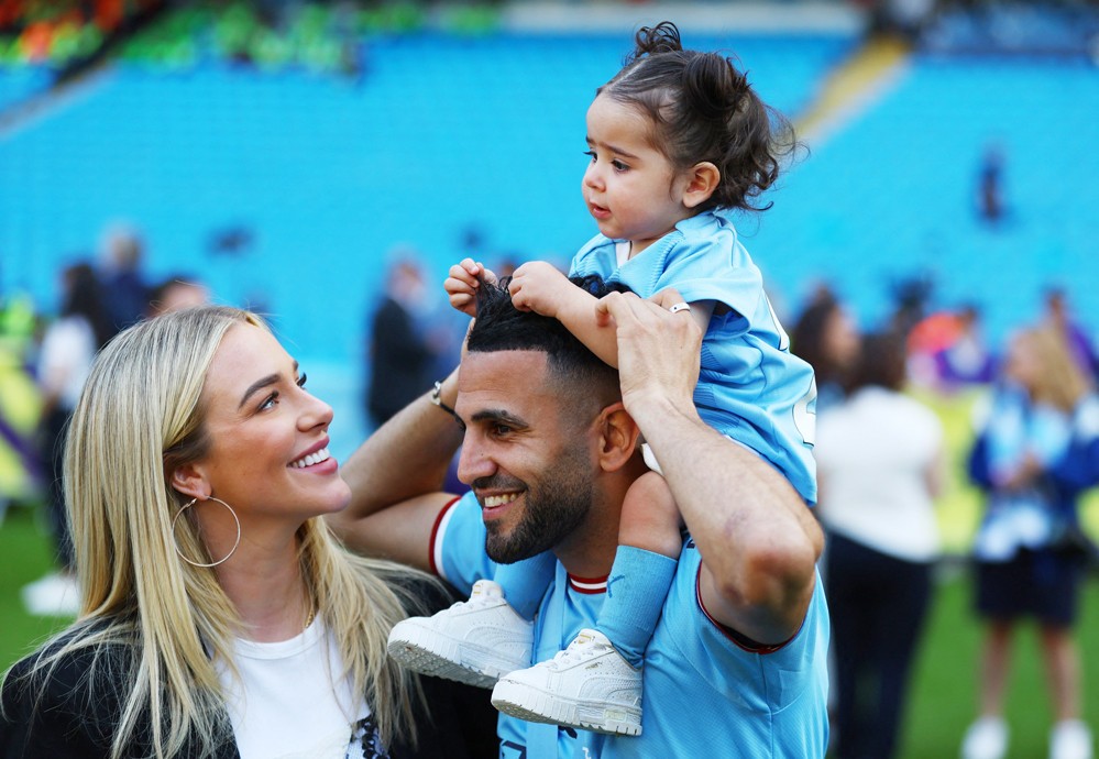 Tiền vệ cánh phải Riyad Mahrez đeo huy chương dành cho nhà vô địch Premier League khi được bạn gái, người mẫu Taylor Ward và con gái đến sân Etihad chung vui.