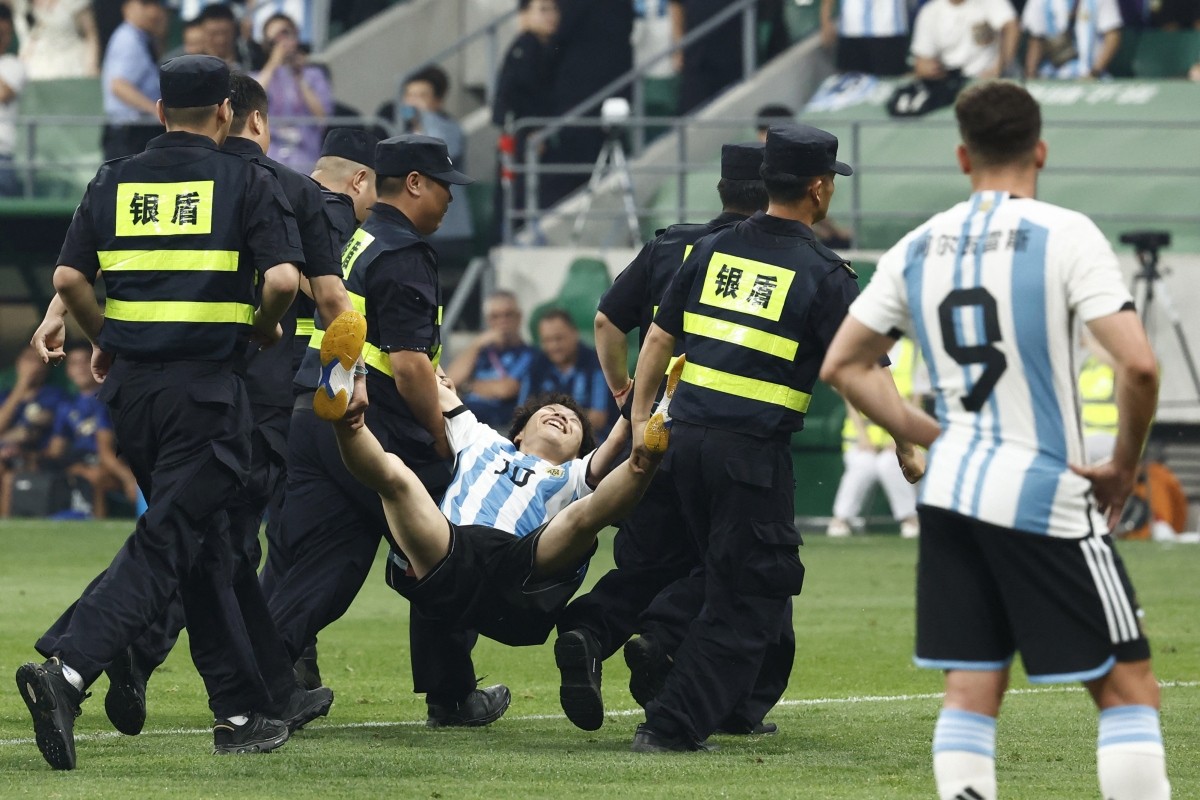 Sau một lúc, cổ động viên mặc áo số 10 của Messi bị lực lượng an ninh khiêng ra ngoài nhưng anh vẫn nở một nụ cười rạng rỡ, hạnh phúc.