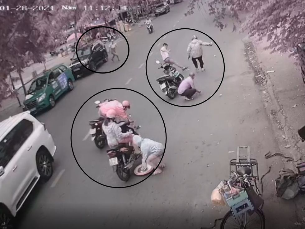 Người đàn ông lái xe ta xi tranh giành tiền với người đàn ông đi xe Air Blade, lúc này có thêm người đàn ông từ chiếc ô tô màu đen cũng mở cửa xuống xe