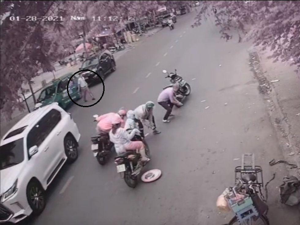 Người đàn ông lái taxi màu xanh tiến lại để nhặt tiền