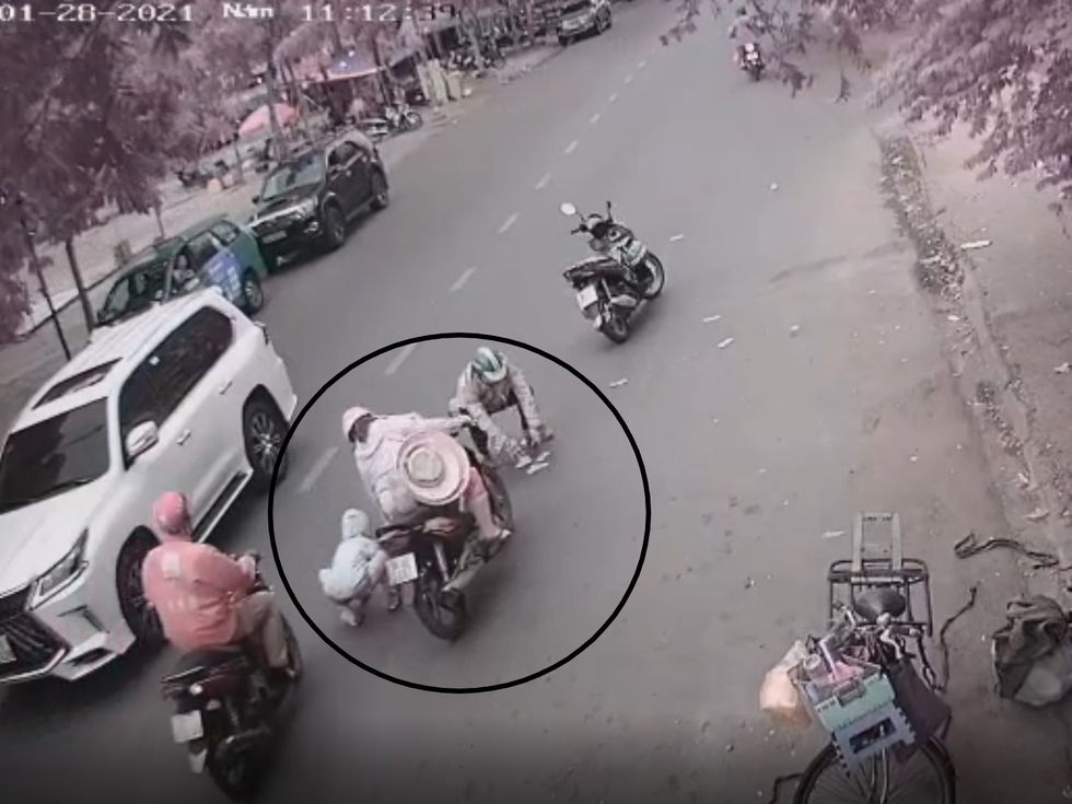 Người đàn ông đi xe Air Blade cũng đậu xe lại và đến nhặt tiền, cùng lúc này một người phụ nữ chở theo trẻ em cũng dừng lại nhặt tiền, người đàn ông mặc áo đỏ cũng đang tiến đến