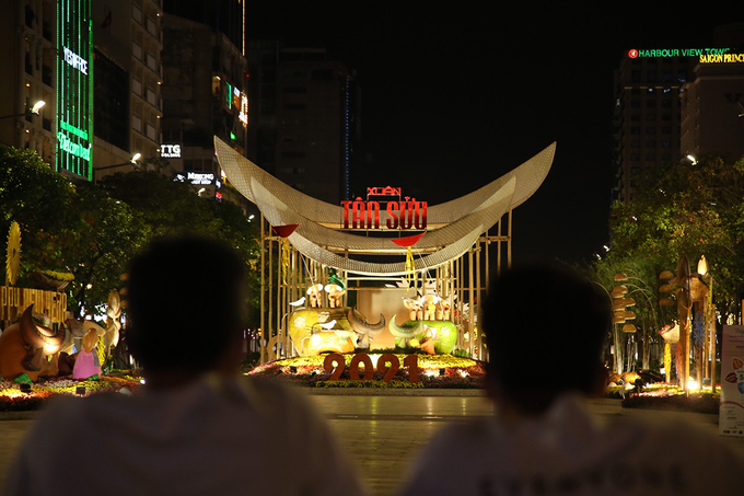 Tại TP HCM, người dân cũng đang đổ về đường hoa Nguyễn Huệ. Dù vậy đường hoa không mở cửa vào buổi tối do dịch Covid-19 nên nhiều người cũng chỉ đứng từ đằng xa. Ảnh: VNE
