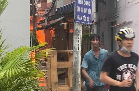 Anh Tựu (áo xanh) chạy khỏi vụ cháy. Ảnh: Tuổi Trẻ Anh Tựu (áo xanh) chạy khỏi vụ cháy. Ảnh: Tuổi Trẻ