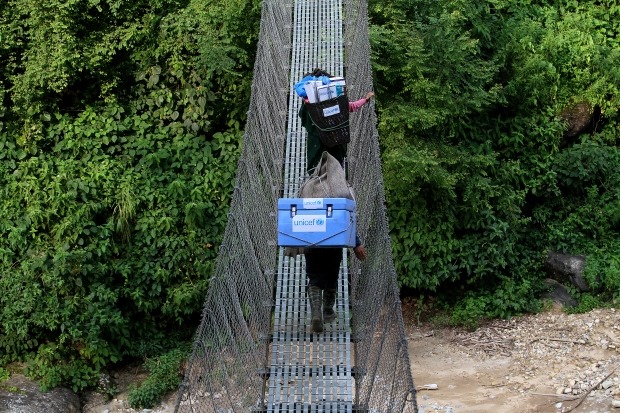 Những người khuân vác và một nhân viên y tế địa phương mang vắc xin đi trên địa hình khó khăn tới một trạm y tế ở Gorkha, Nepal năm 2015. Ảnh: UNICEF