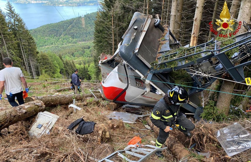 Lực lượng chức năng kiểm tra hiện trường vụ tai nạn đứt cáp treo đã cướp đi sinh mạng của 14 người tại vùng Piedmont, Italia ngày 23/5. Nguyên nhân vụ việc do đứt cáp và hệ thống phanh khẩn cấp không hoạt động khiến chiếc cabin chở 15 người trôi ngược, va vào trụ cáp và rơi xuống. Ảnh: AP