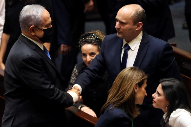 Ông Benjamin Netanyahu (trái) bắt tay với chính trị gia cực hữu Naftali Bennett. Ảnh: Reuters