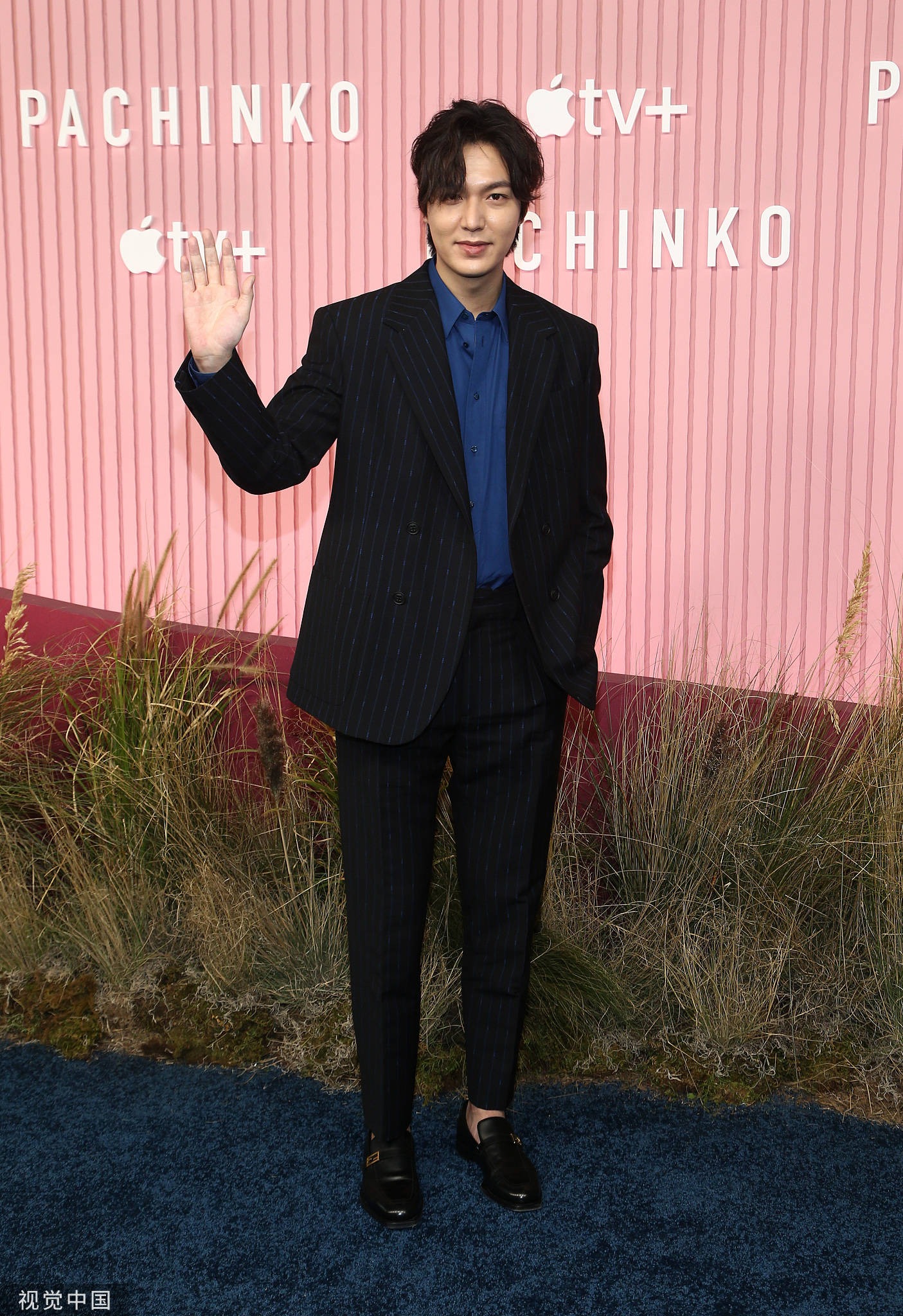 Lee Min Ho vẫy tay chào trước ống kính. Mái tóc để dài, lòa xòa che kín mắt, má chảy xệ, mắt sưng khiến anh già đi rất nhiều.